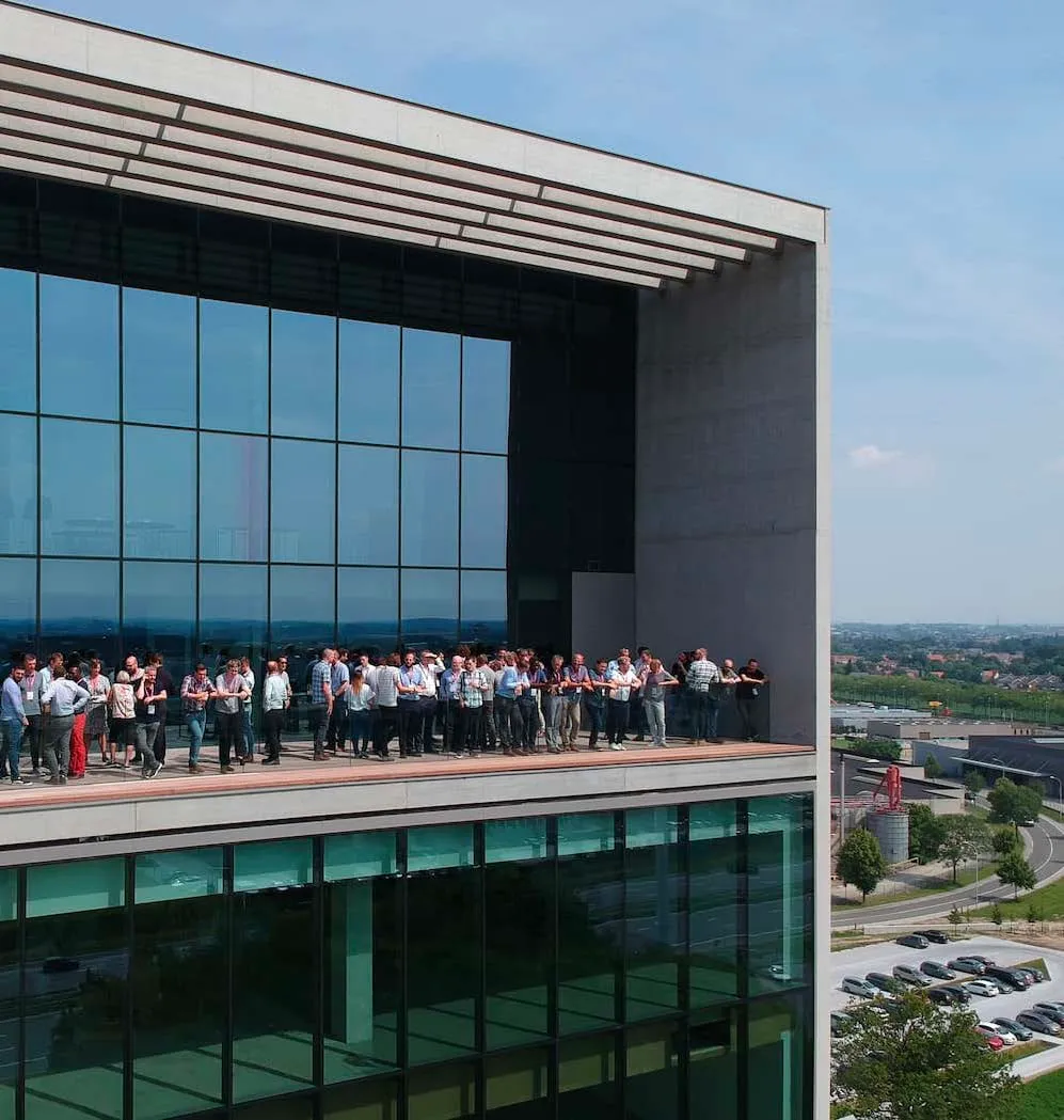 Groep professionals op de SkyBar van een Skyline Park in Izegem, met zicht op de omgeving.